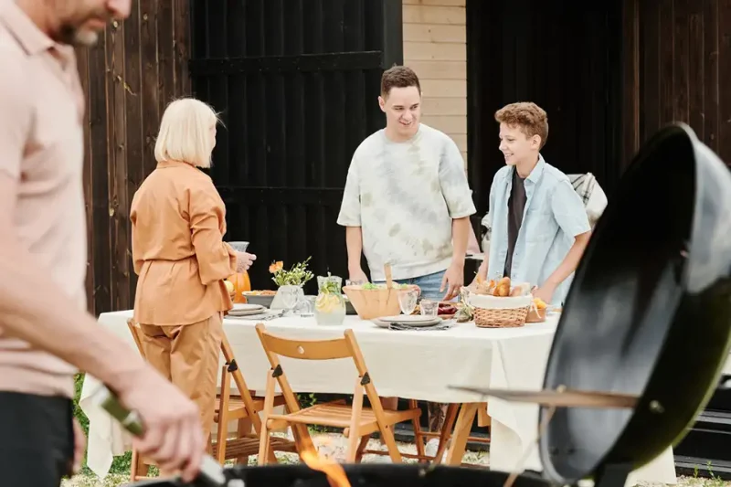 A joyful family enjoying a sunny day with a delightful backyard barbecue meal.